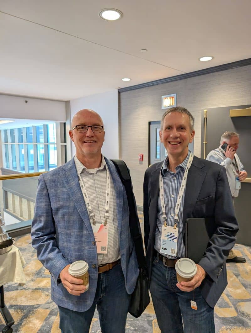Jeff Crume with a colleague in a conference hallway at IBM Think 2025, both wearing Think lanyards